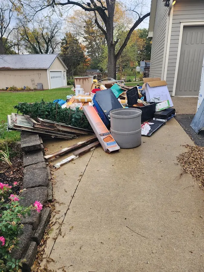 Dumpster being loaded with debris for Estate Cleanout Dumpster Rental in Pace